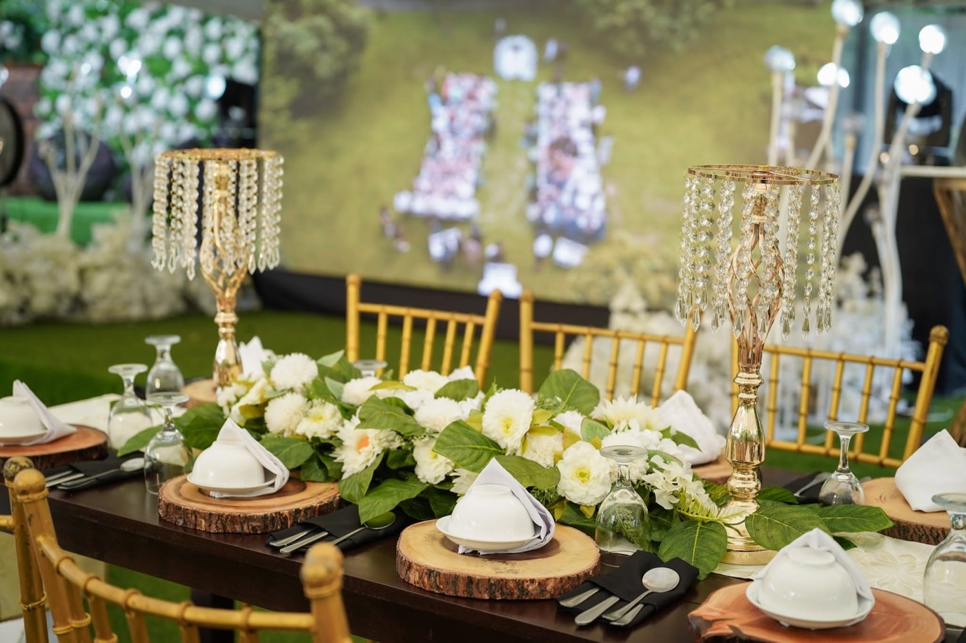 An outdoor reception with crystal candelabra centerpieces and string lights